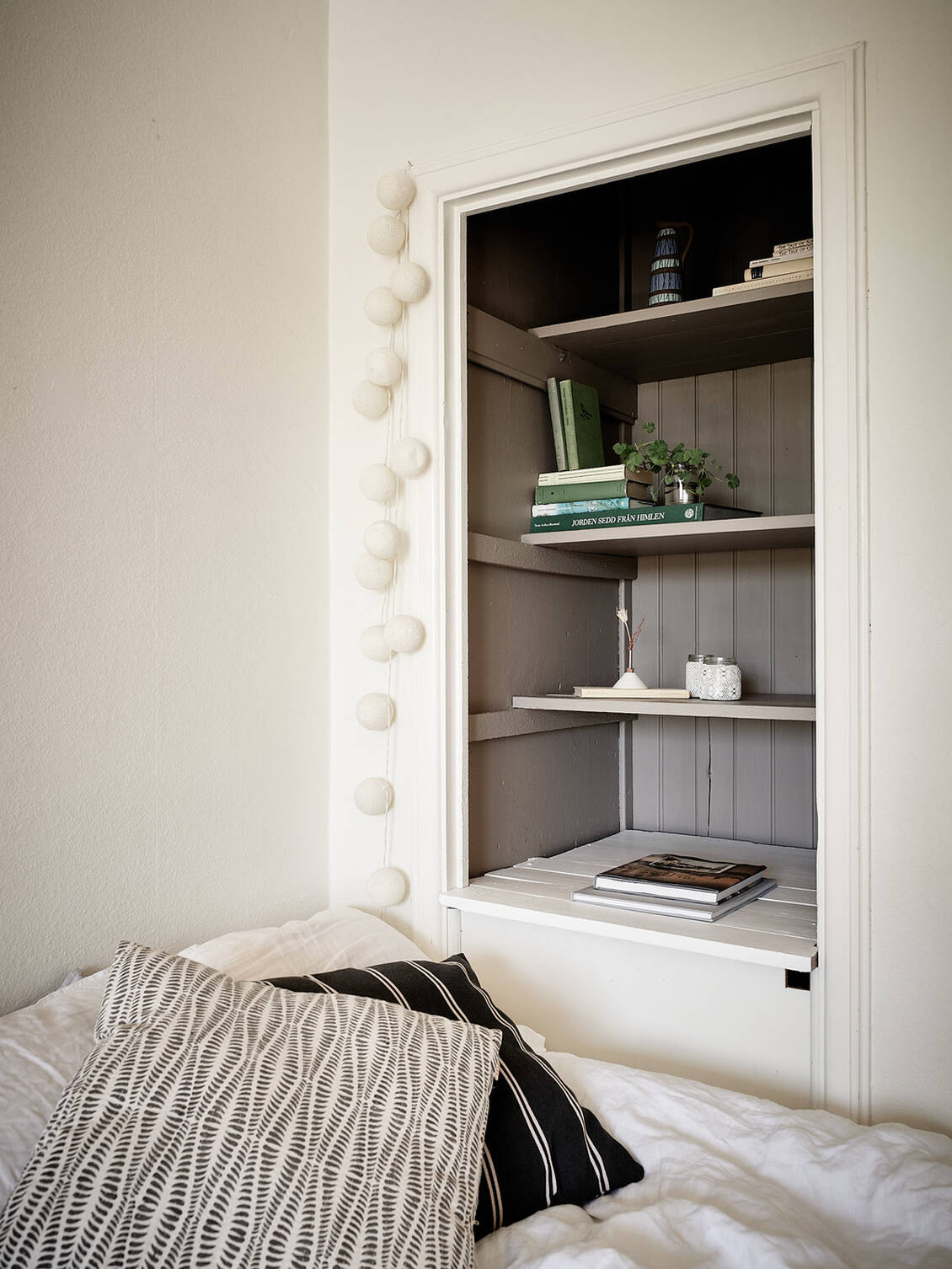 Intill sängen finns en inbyggd bokhylla med charmiga originalsnickerier. 